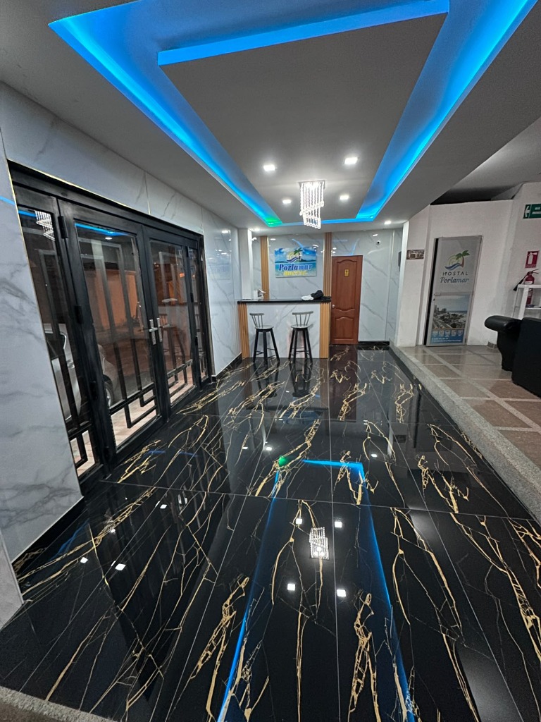 Lobby y recepción de Hostal Porlamar con acabados de lujo